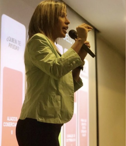 Yfigenia Moreno como conferencista, hablando ante una audiencia